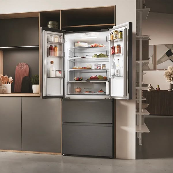 Rfrigrateur  double porte en haut et tiroirs en bas, intgr dans une cuisine design, avec des aliments frais rangs de manire organise.