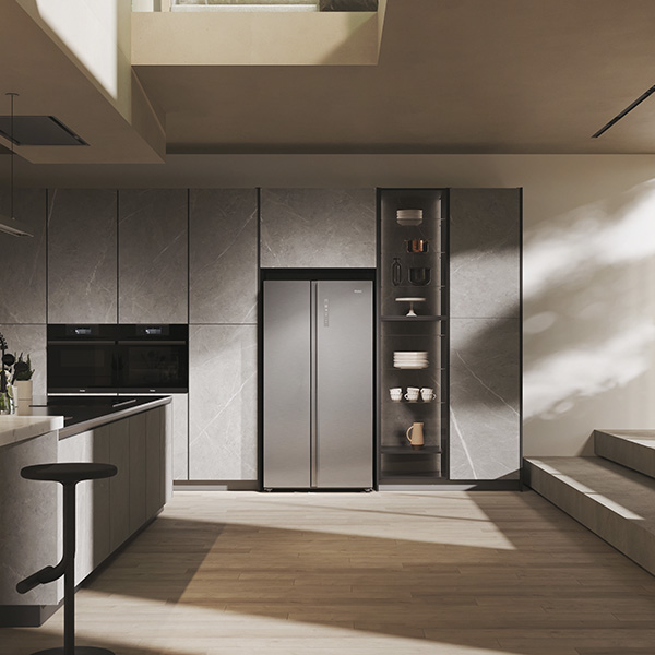 Cuisine moderne avec rfrigrateur encastr en inox intgr dans des armoires murales grises.