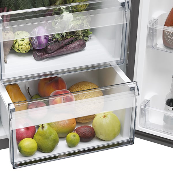 Gros plan sur deux tiroirs transparents remplis de fruits et lgumes frais  l'intrieur d'un rfrigrateur.