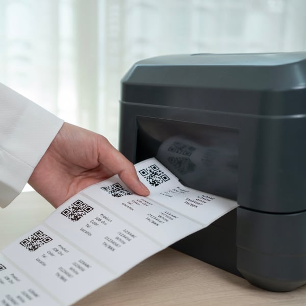Imprimante thermique imprimant une s�rie d��tiquettes autocollantes avec codes QR.