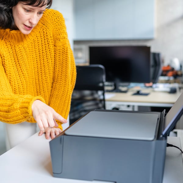 Chargement de feuilles dans le bac papier d�une imprimante de bureau.
