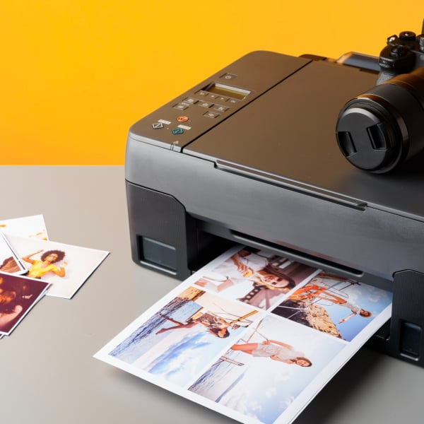 Imprimante photo imprimant des clich�s couleur, avec un appareil photo pos� � c�t�.