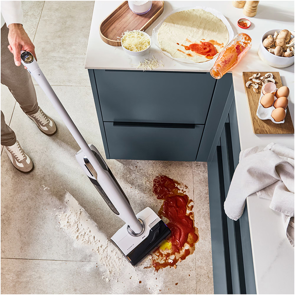 Aspirateur laveur nettoyant des liquides renvers�s et de la farine sur le sol de la cuisine