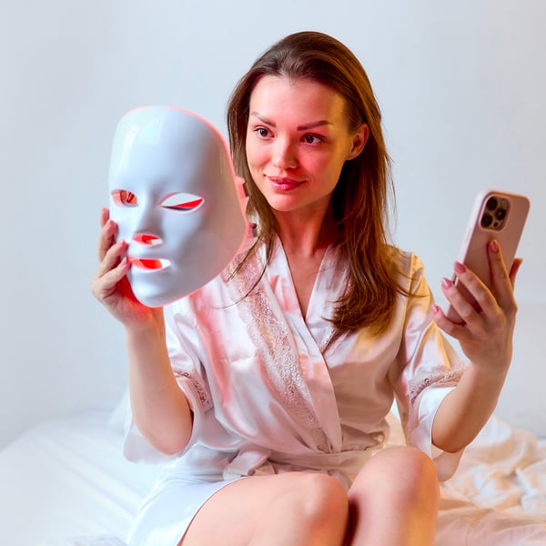 Een vrouw kijkt naar haar LED-masker