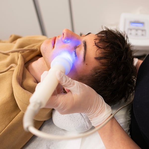 Een man die een behandeling met blauw licht krijgt