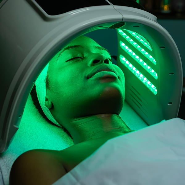 Een vrouw die een behandeling met groen licht krijgt