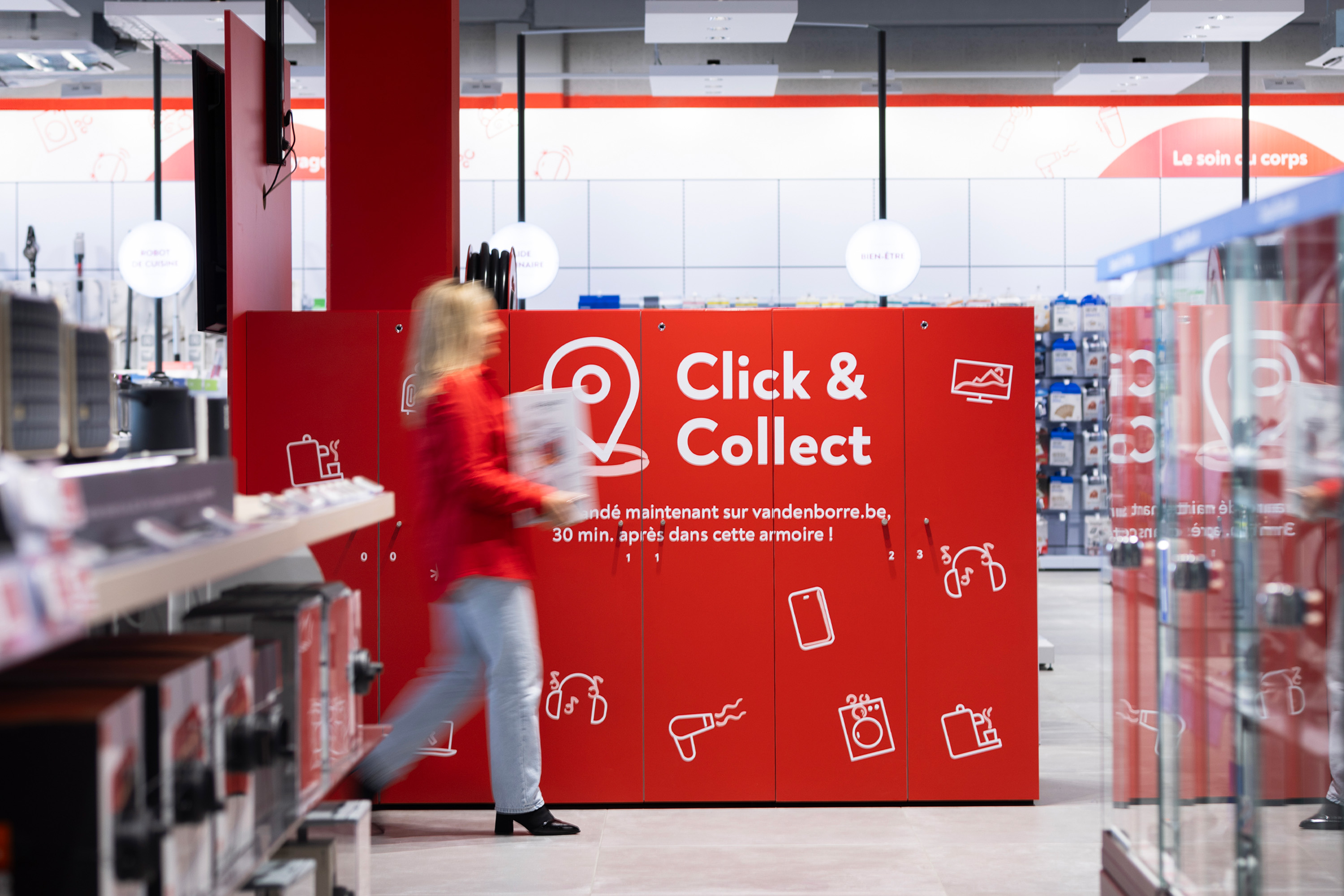 Une femme vient chercher un colis dans un magasin Vanden Borre