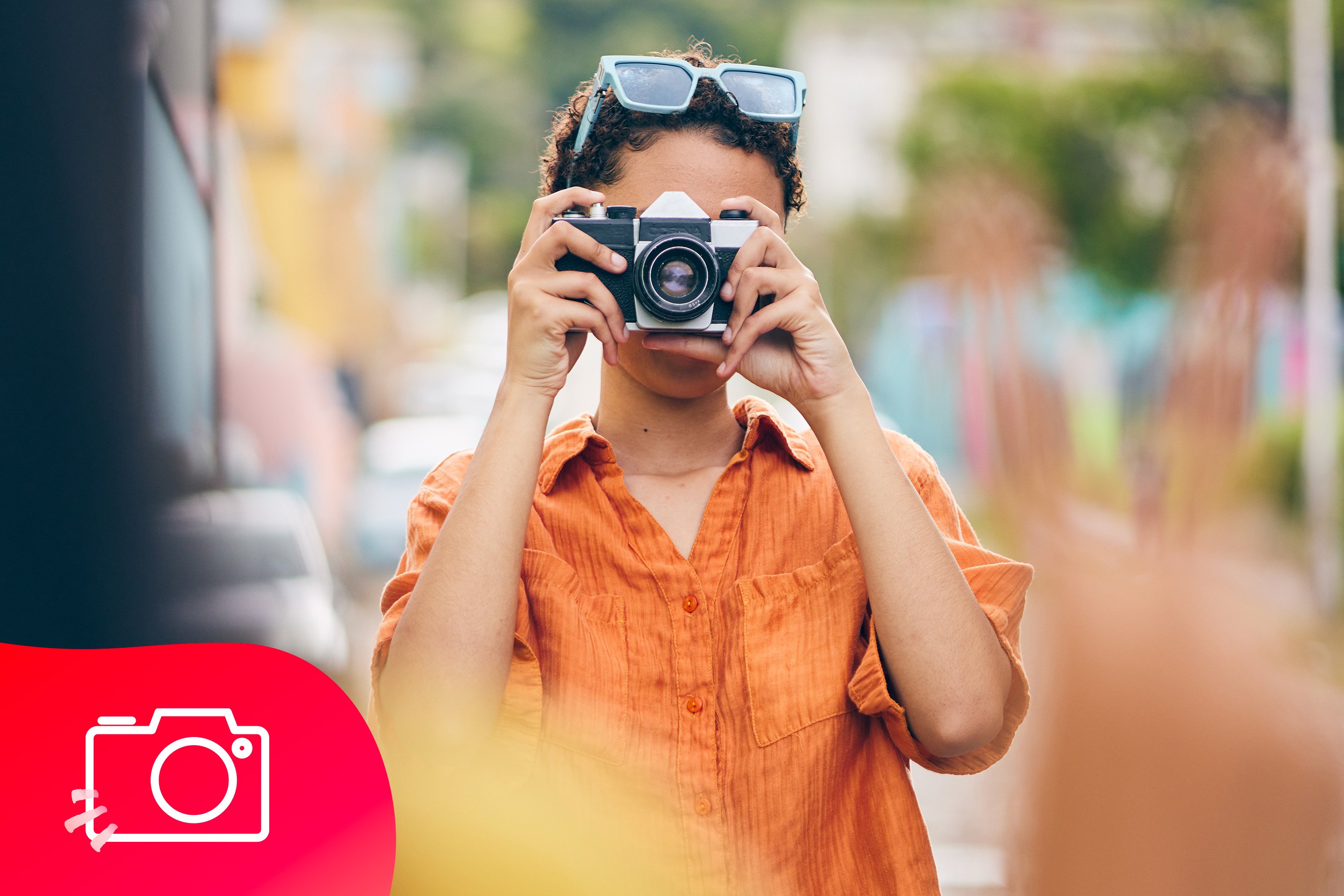 Een vrouw met kort haar maakt een foto met een camera