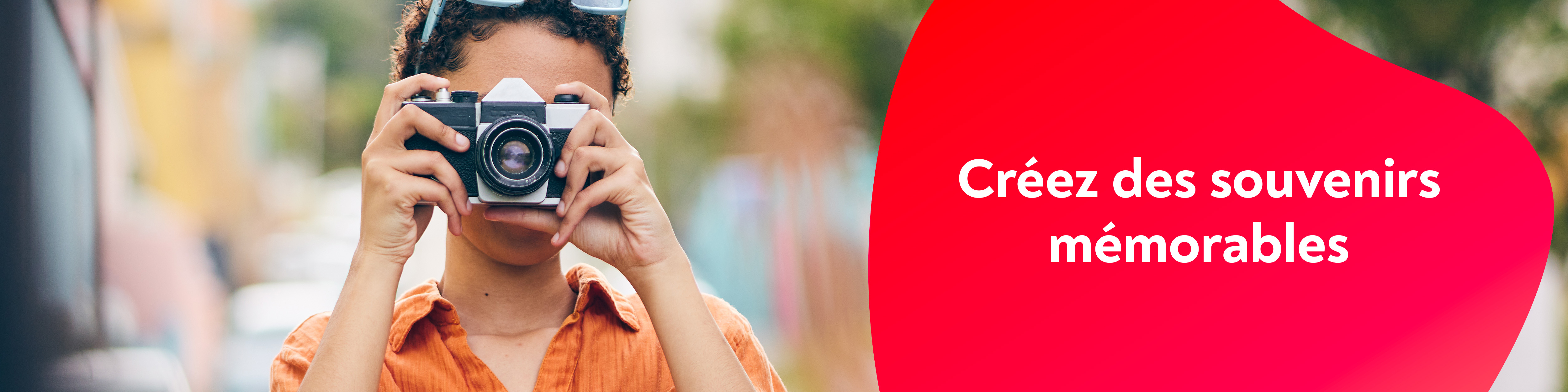 Une femme avec un appareil photo r�flex, au milieu d'un chemain de campagne.