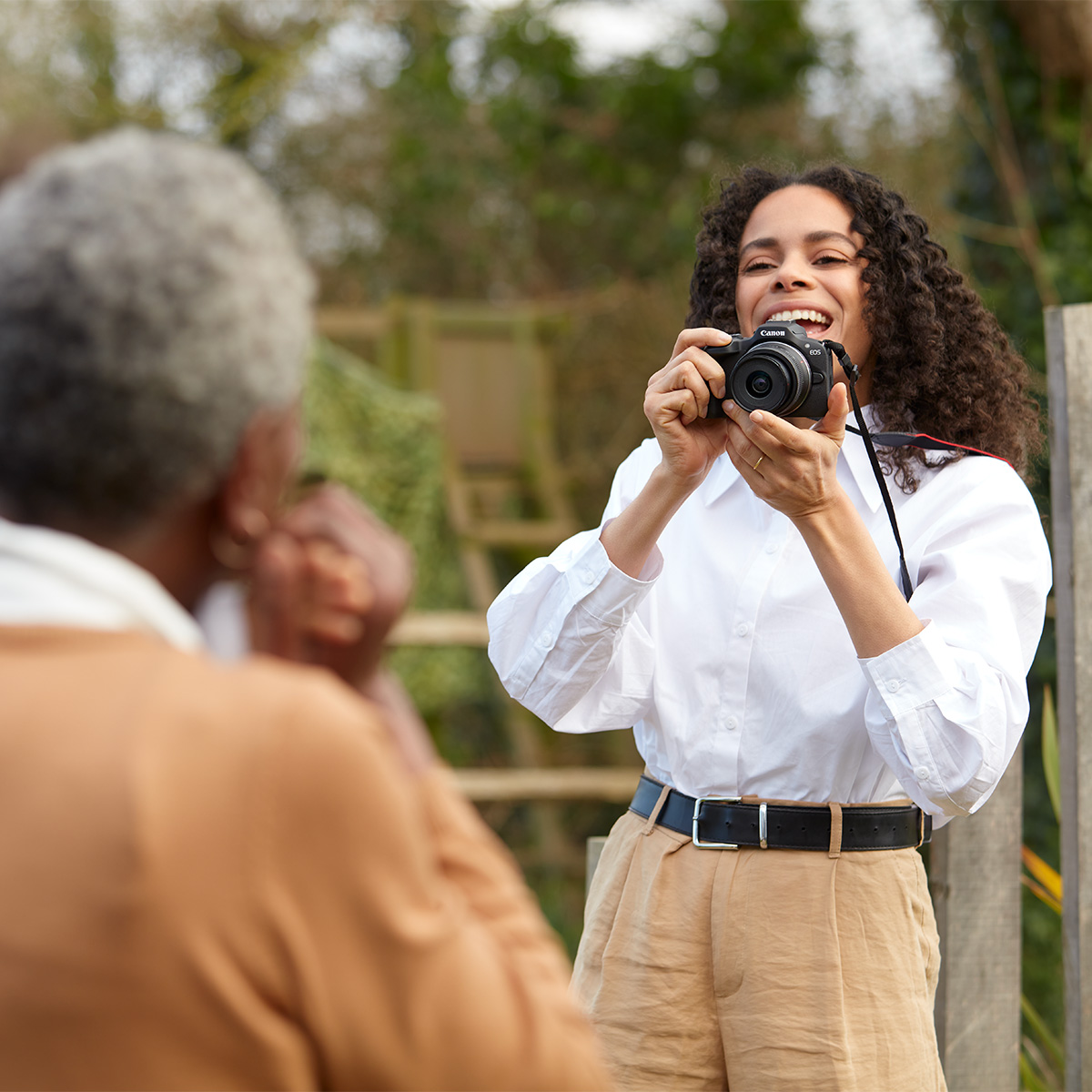 Een lachende vrouw neemt een foto van iemand