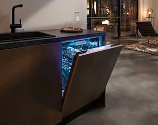 Een bruine inbouwvaatwasser waarvan de deur lichtjes open staat