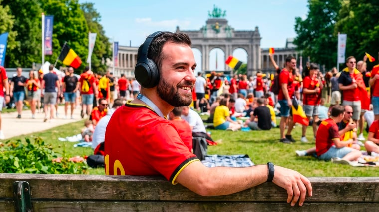 Een man zit op een bank met zijn hoofdtelefoon op