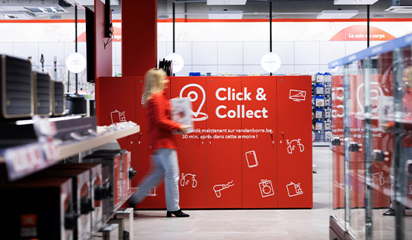 Een Vanden Borre-medewerkster brengt een keukentoestel naar de Click&Collect-kast, klaar om opgehaald te worden door de klant. 