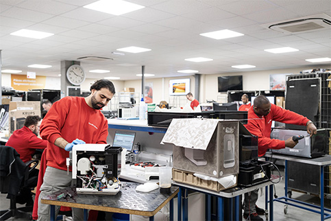 5 sp�cialistes Vanden Borre en train de r�parer diff�rents appareils dans les ateliers de r�paration.