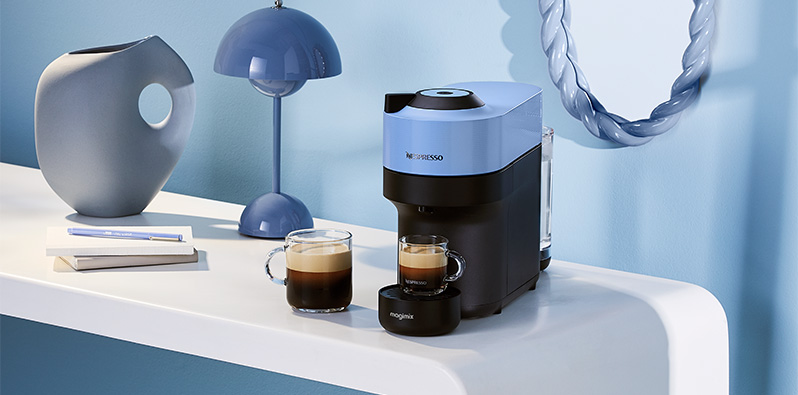 Een blauwe Nespresso koffiemachine met twee soorten koffie