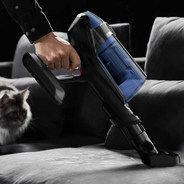 Een persoon die een zetel stofzuigt met de Rowenta X-Force Flex 12.60