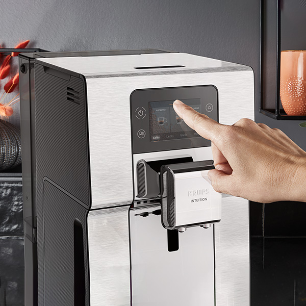 Une personne qui utilise lcran tactile de machine  caf la Krups Intuition Experience + 