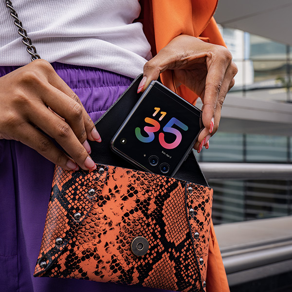 Een vrouw die haar opvouwbare Motorola razr 40 ultra-smartphone in haar tas stopt 