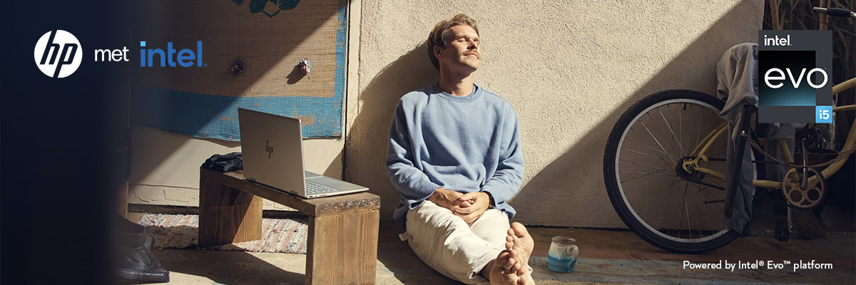 Een man zit op de grond met zijn HP-laptop 