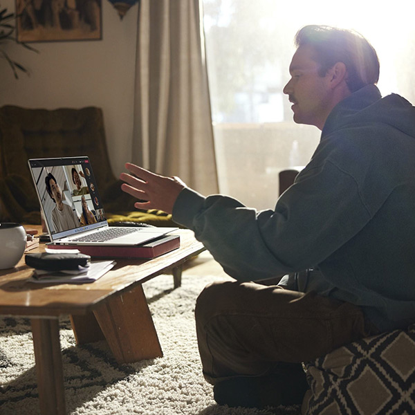 Un homme assis dans son salon qui fait une r�union avec son PC portable HP 
