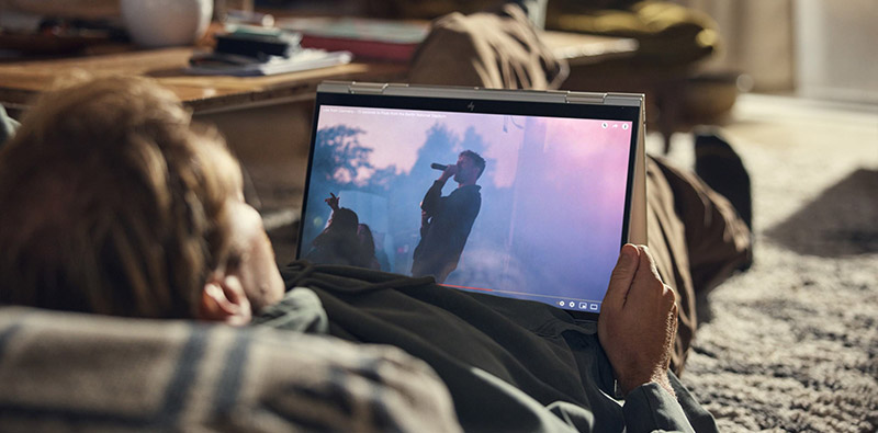 Un homme allong� par terre qui regarde une vid�o YouTube sur son PC portable HP 