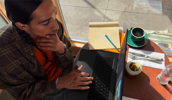 Un homme dans un caf� qui travaille avec son MacBook Pro