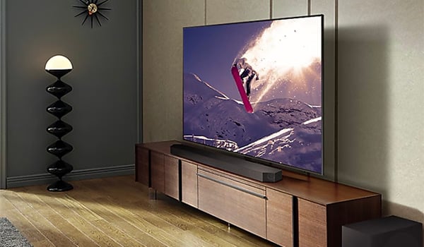 Une barre de son sous une TV sur un meuble