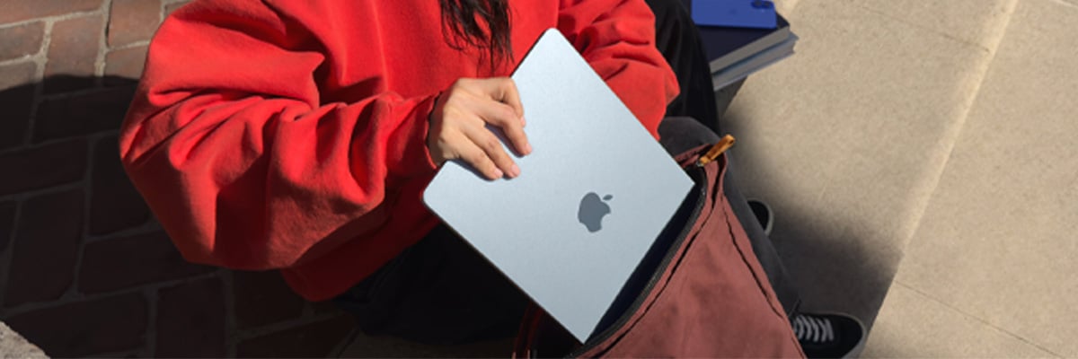 Une tudiante met son MacBook dans son sac