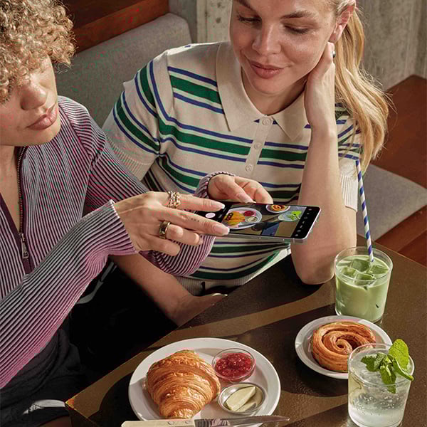 Een vrouw neemt een foto van haar ontbijt met de Galaxy S25 Edge