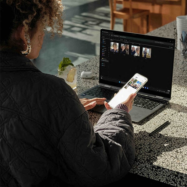 Een vrouw zet foto's van haar Galaxy S25 Edge over naar haar laptop 