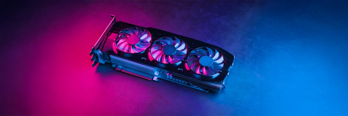 Carte graphique �quip�e de trois ventilateurs pos�e sur une surface sombre avec un �clairage rose � gauche et bleu � droite