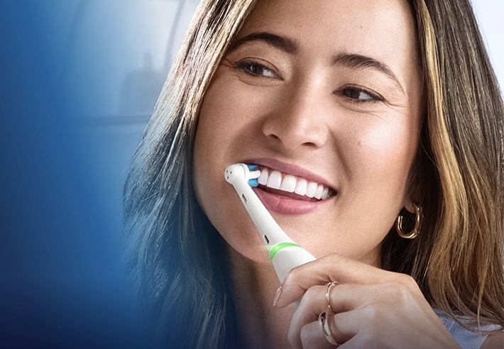 Persoon die een elektrische tandenborstel op de tanden gebruikt, close‑up van het onderste deel van het gezicht