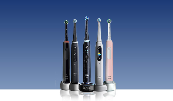 Vijf elektrische tandenborstels in verschillende kleuren op hun oplaadstations tegen een blauwe achtergrond