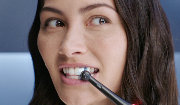 Close‑up van een persoon die een elektrische tandenborstel op de tanden gebruikt