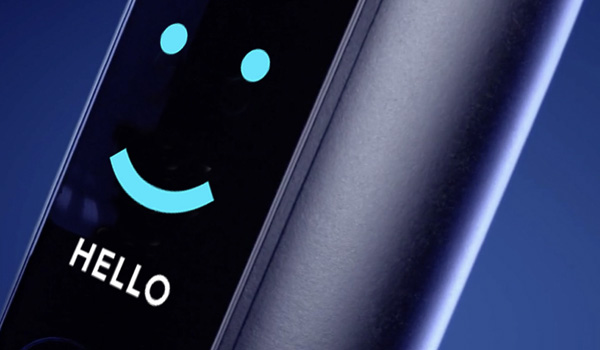 Scherm van een elektrische tandenborstel met een lichtgevend gestileerd gezicht en het woord HELLO