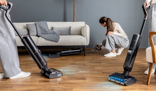 Een vrouw reinigt onder de zetel met de flexibele steel van de X-Clean 7