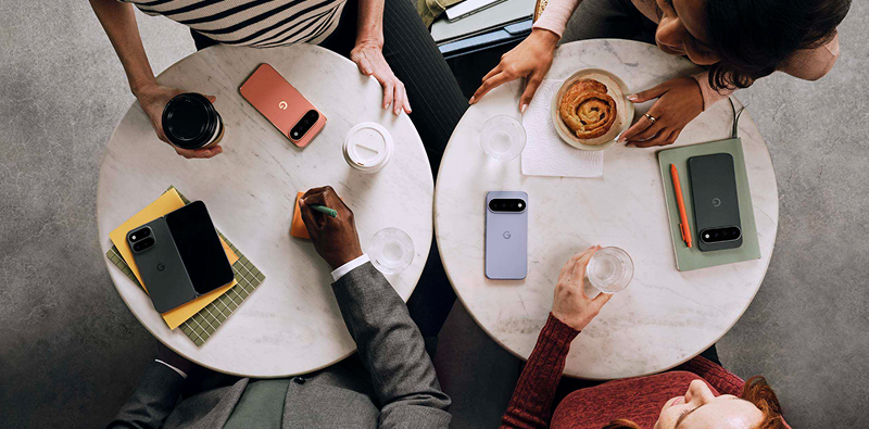 Vier mensen zitten te lunchen met hun Google Pixel 11 Pro op tafel