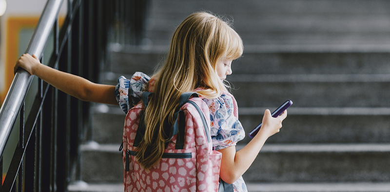Personne avec sac � dos regardant un smartphone.