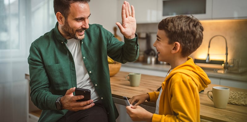Adulte et enfant avec un smartphone.