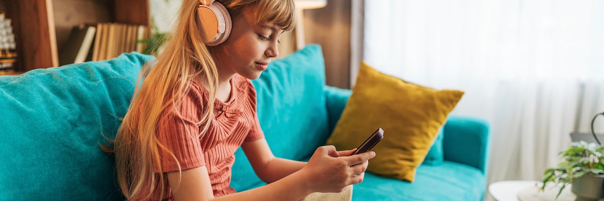 Personne avec smartphone et casque audio.